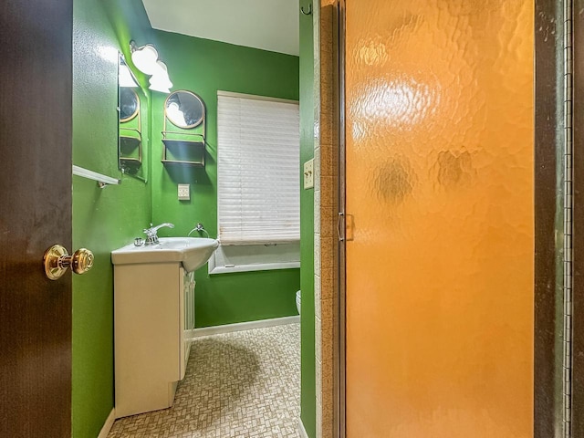 full bathroom with a shower with shower door and vanity