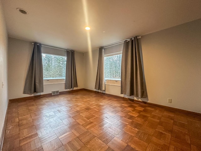 empty room featuring visible vents and baseboards