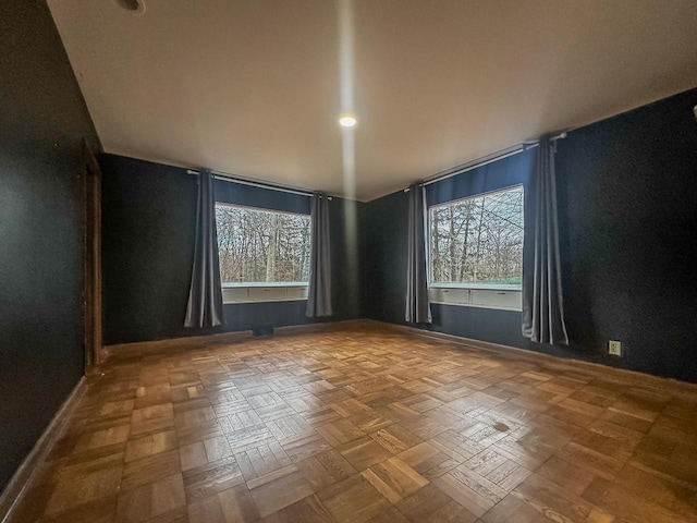 empty room featuring plenty of natural light and baseboards