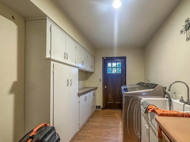 laundry area featuring cabinet space, independent washer and dryer, and light wood finished floors