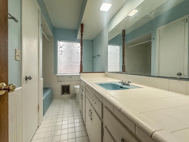 bathroom with tile patterned flooring, tile walls, toilet, and vanity