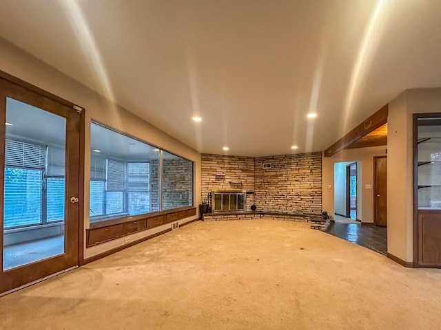 unfurnished living room featuring carpet floors, a stone fireplace, visible vents, and recessed lighting