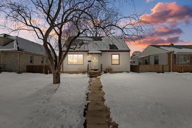 snow covered house with fence