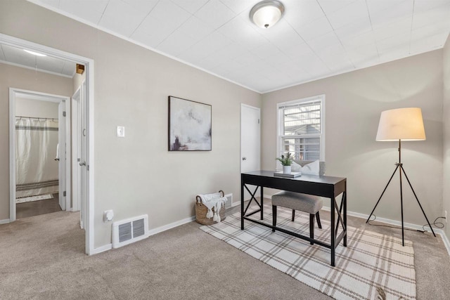 carpeted office featuring baseboards, visible vents, and crown molding