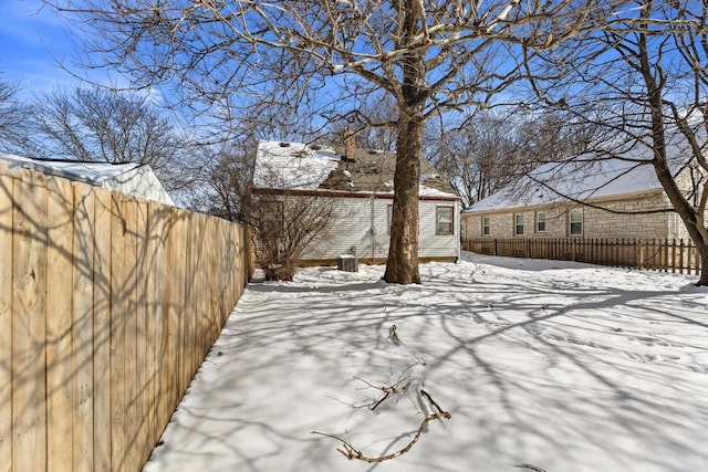 yard covered in snow with fence