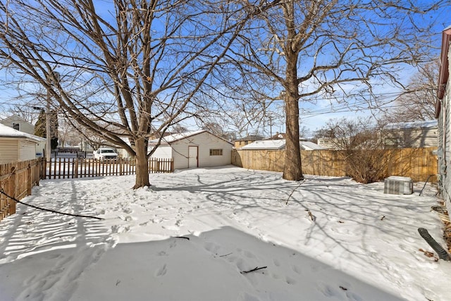 yard covered in snow featuring an outbuilding, central AC unit, and fence private yard