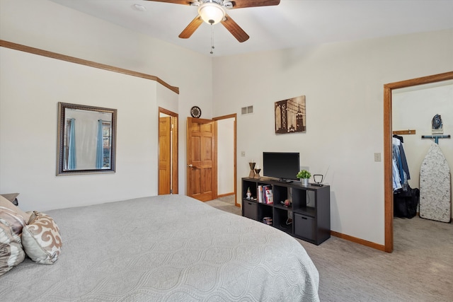 carpeted bedroom with lofted ceiling, visible vents, a ceiling fan, a closet, and a walk in closet