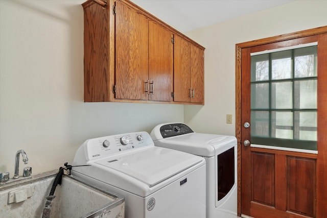 laundry room featuring independent washer and dryer, a sink, and cabinet space