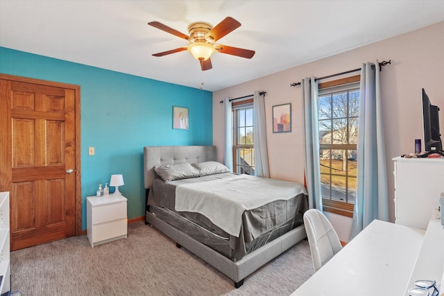 carpeted bedroom with ceiling fan and baseboards