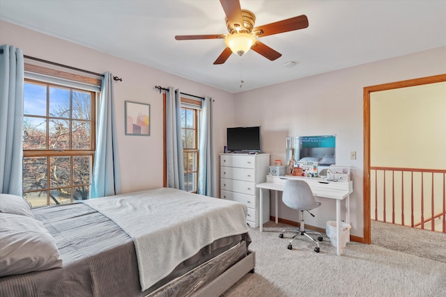 carpeted bedroom with ceiling fan, multiple windows, and baseboards