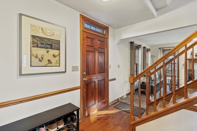 entrance foyer featuring stairs, visible vents, baseboards, and wood finished floors