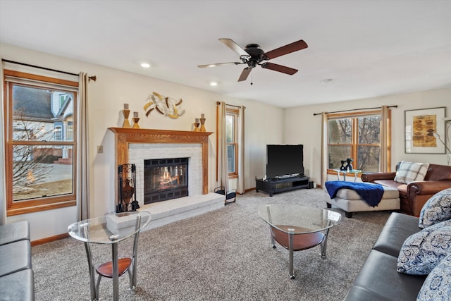 living room with baseboards, ceiling fan, carpet, a brick fireplace, and recessed lighting