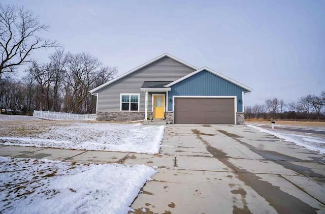 view of front of house with a garage, stone siding, and concrete driveway