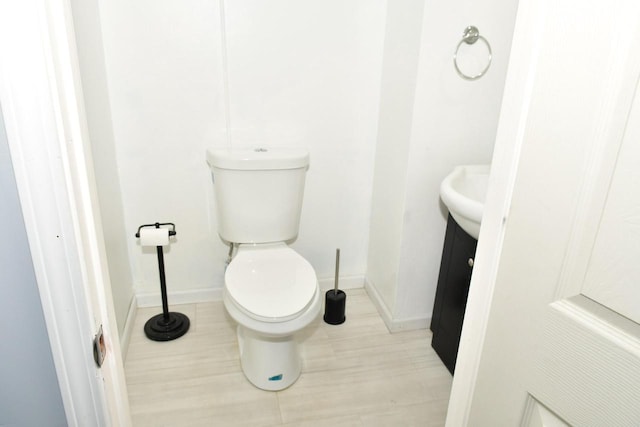 bathroom featuring vanity, toilet, and baseboards