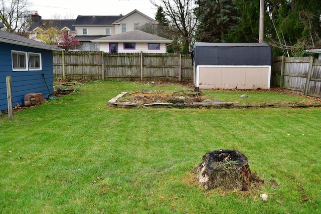 view of yard featuring a fenced backyard, a storage unit, and an outdoor structure