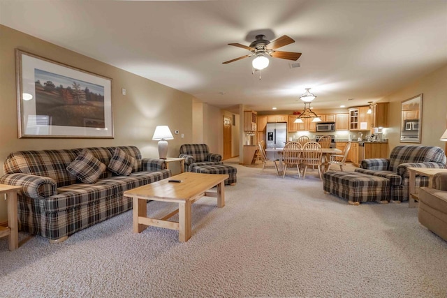 living area with a ceiling fan and light carpet