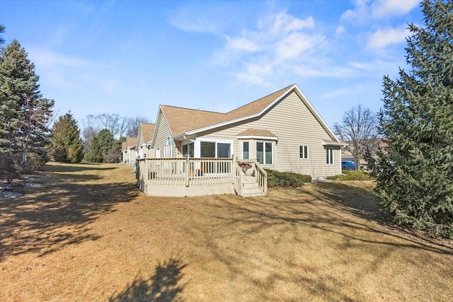 rear view of house with a yard and a wooden deck