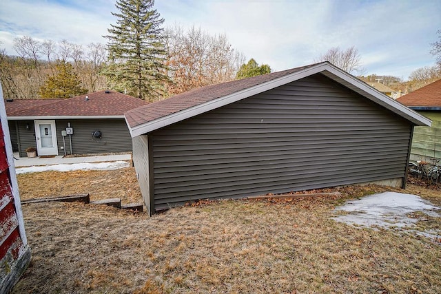 view of side of home with roof with shingles