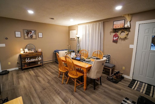 dining area featuring a textured ceiling, baseboards, wood finished floors, and recessed lighting