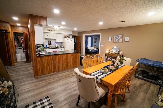 dining space featuring recessed lighting, visible vents, a textured ceiling, and light wood finished floors