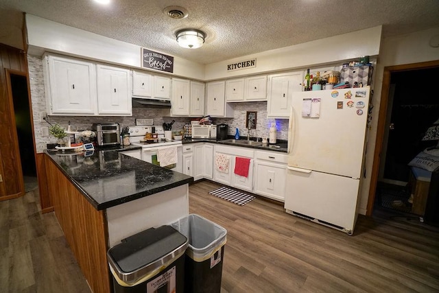 kitchen with dark wood-style flooring, visible vents, white cabinets, white appliances, and under cabinet range hood