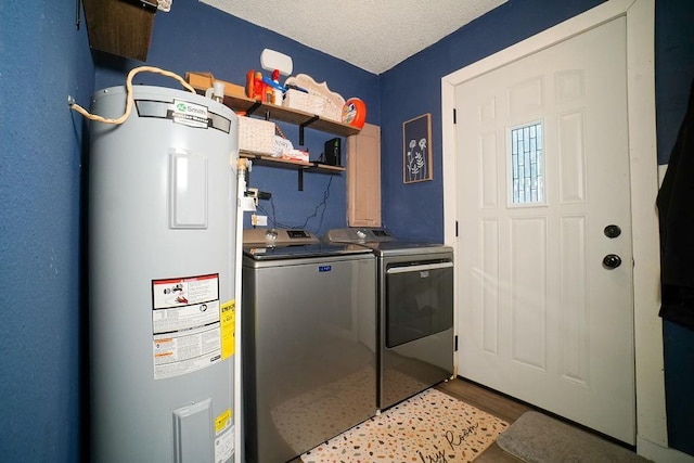 clothes washing area featuring a textured ceiling, light wood-style flooring, laundry area, separate washer and dryer, and water heater