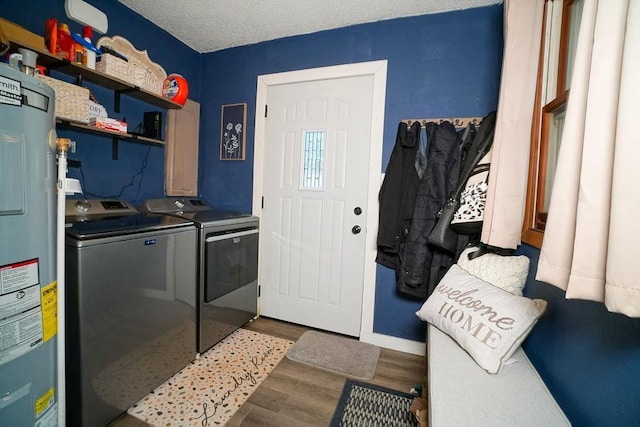 washroom featuring electric water heater, a textured ceiling, wood finished floors, laundry area, and independent washer and dryer