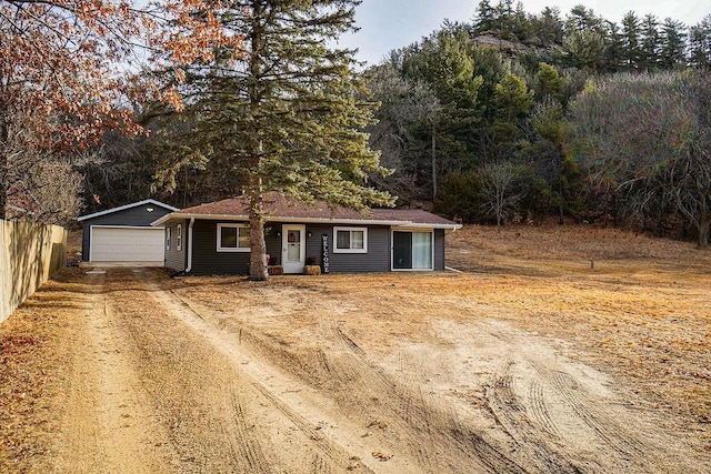 view of front of house with an outbuilding, driveway, fence, and a garage