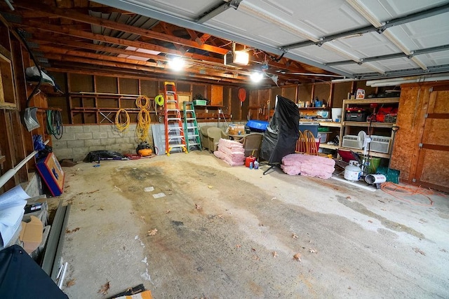 garage featuring a garage door opener and concrete block wall