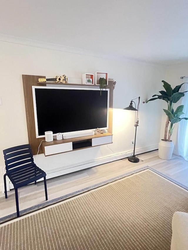 interior space with baseboards, wood finished floors, and crown molding