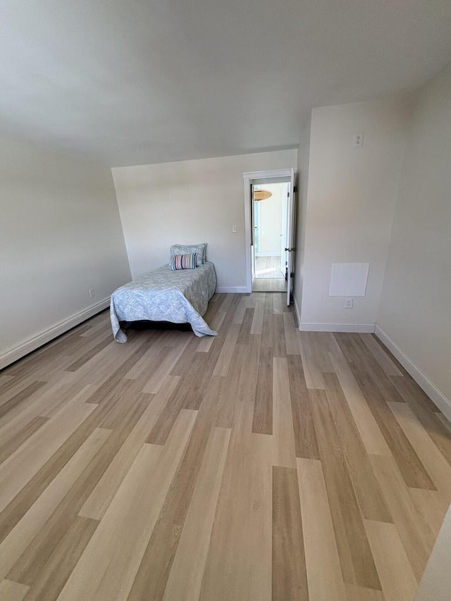 unfurnished bedroom featuring light wood-type flooring and baseboards