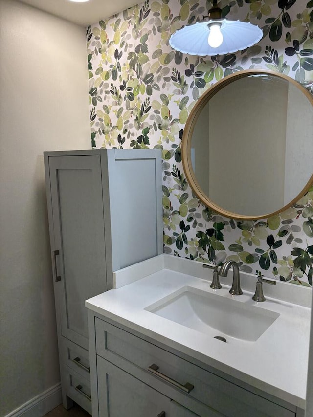 bathroom with wallpapered walls and vanity