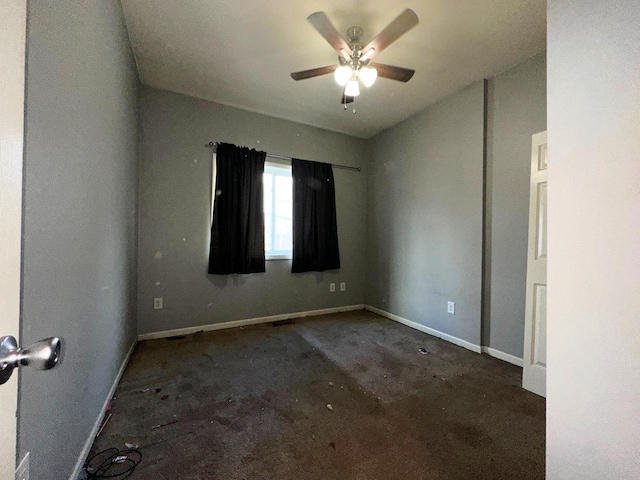 spare room with baseboards and ceiling fan