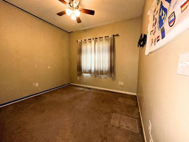 carpeted empty room featuring a ceiling fan and baseboards