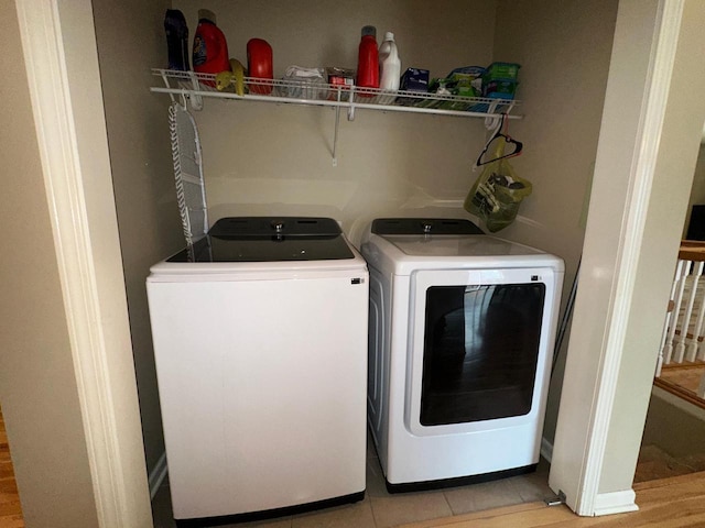 clothes washing area featuring light tile patterned flooring, laundry area, and washing machine and dryer