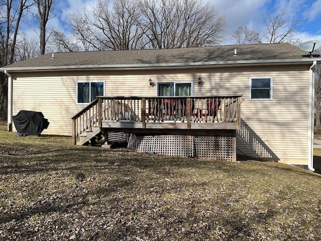 rear view of house featuring stairway, roof with shingles, and a deck