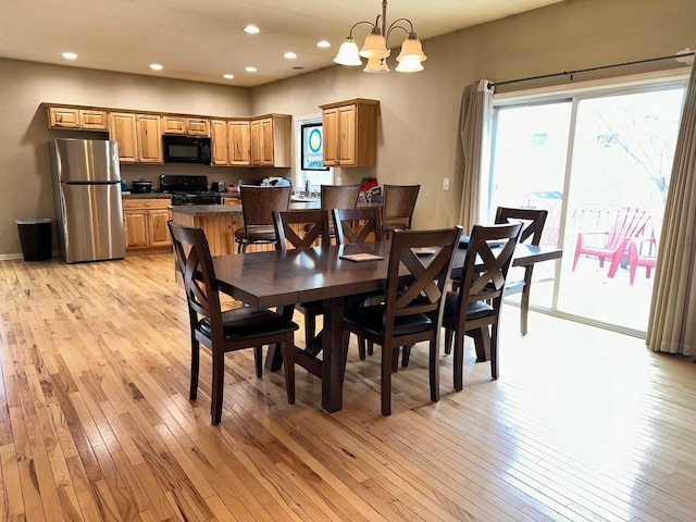 dining space with recessed lighting, a notable chandelier, and light wood-style flooring