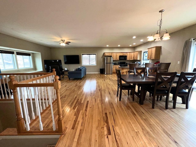 dining area with ceiling fan with notable chandelier, recessed lighting, light wood-type flooring, and baseboards