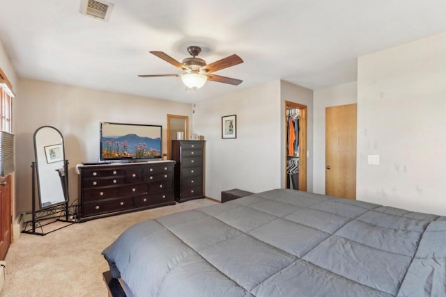 bedroom with visible vents, a walk in closet, a ceiling fan, a closet, and carpet floors