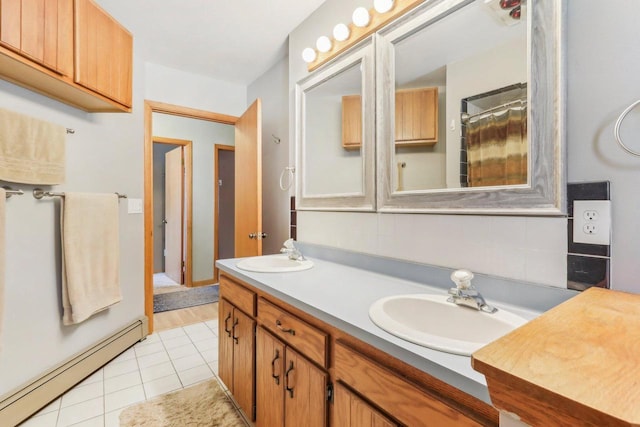 full bathroom featuring a baseboard heating unit, tile patterned floors, double vanity, and a sink