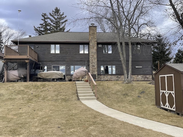 back of house featuring an outbuilding, a chimney, a storage shed, and stairs