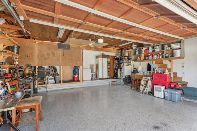 garage with fridge, a garage door opener, and freestanding refrigerator