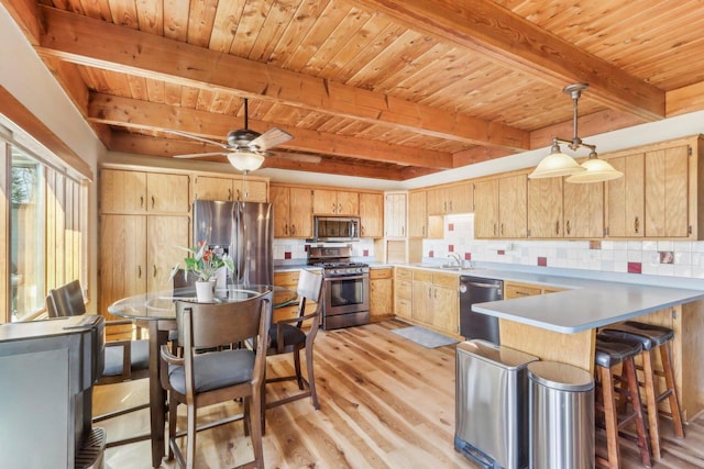 kitchen featuring tasteful backsplash, light brown cabinetry, light wood-type flooring, appliances with stainless steel finishes, and a peninsula