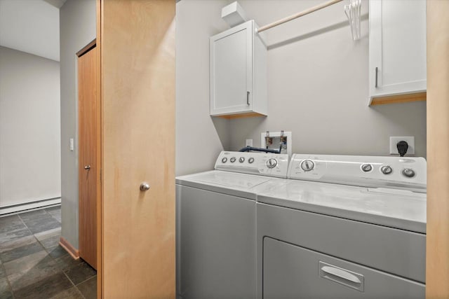 clothes washing area with a baseboard heating unit, separate washer and dryer, stone finish floor, and cabinet space