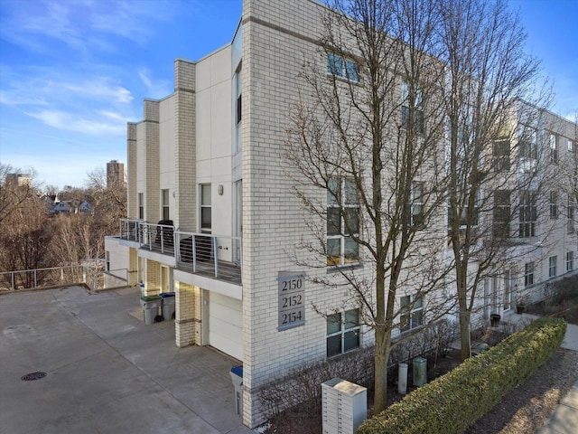 view of building exterior with concrete driveway and a garage