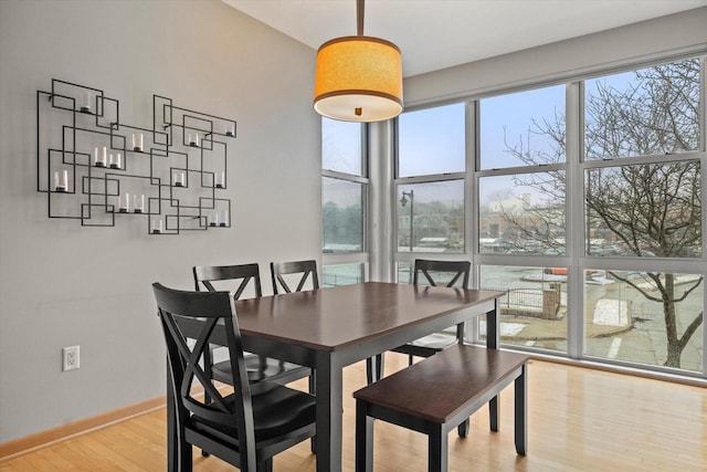 dining space featuring wood finished floors and baseboards