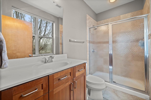 full bath with vanity, a shower stall, toilet, and visible vents