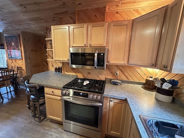 kitchen with wooden walls, wooden ceiling, appliances with stainless steel finishes, open shelves, and a sink