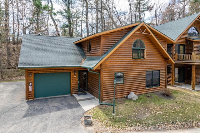 log home with a garage, aphalt driveway, and a shingled roof