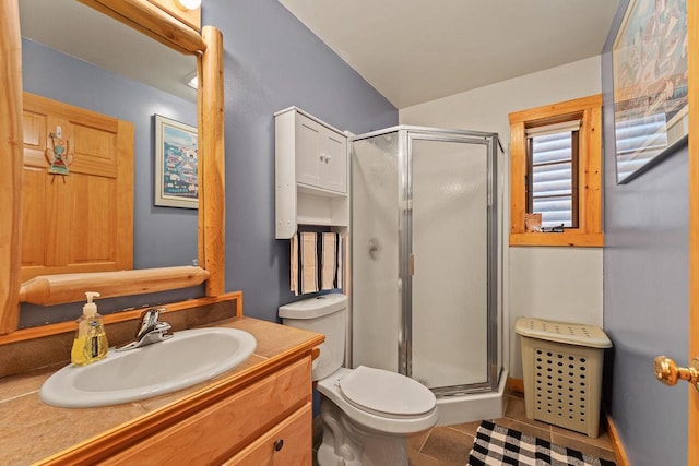 bathroom featuring a stall shower, vanity, toilet, and tile patterned floors